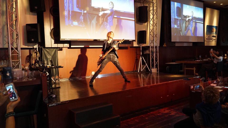 元バンドマンのシーラはベースを弾いて登場。