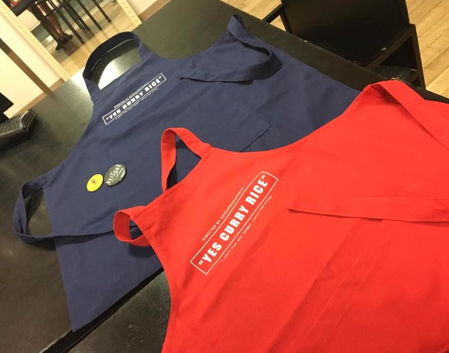 YES CURRY RICEのロゴ。そして缶バッジがエプロンに付いてきます。